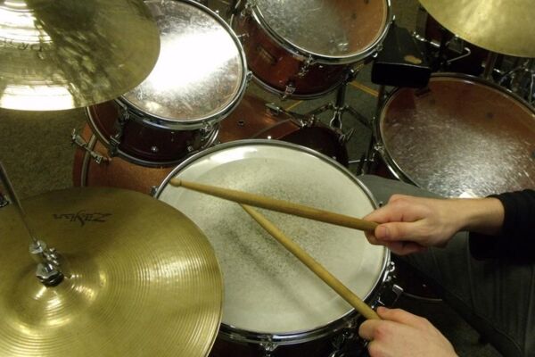 Schlagzeug mit Händen die Sticks halten Link führt zu Schlaginstrumente  Schlagzeug
