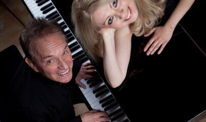 Ekaterina Kitáeva auf Flügel liegend, Walter Renneisen am Flügel spielend, führt zum Kalendereintrag