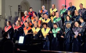 Gruppe aus singenden Frauen und Männern in bunten Roben