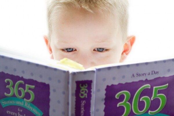 Aufgeklapptes Buch von vorne, dahinter der Kopf von einem lesenden Kind, führt zur Nachricht