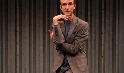 Ein Mann in verknoteter Pose auf Bühne, führt zum Kalendereintrag