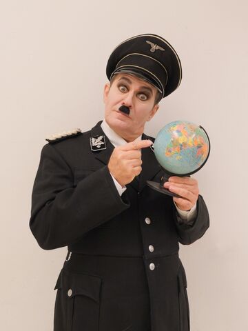 Andreas Guglielmetti als der große Diktator in Uniform mit Globus in der Hand