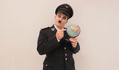 Andreas Guglielmetti als der große Diktator in Uniform mit Globus in der Hand, führt zum Kalendereintrag