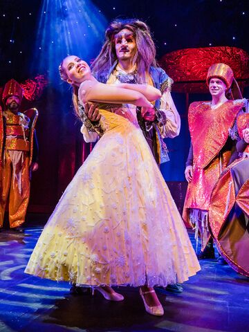 Die Schöne und das Biest tanzend im Vordergrund, dahinter vier Figuren aus der Geschichte stehend