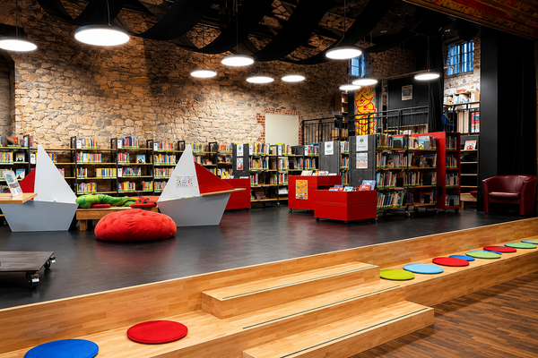 Foto von dem Medienbereich in der Bibliothek mit Regalen und Sitzmöglichkeiten, führt zur Nachricht
