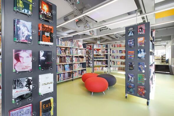 Foto von dem Medienbereich in der Bibliothek mit Regalen und Sitzmöglichkeiten, führt zur Nachricht