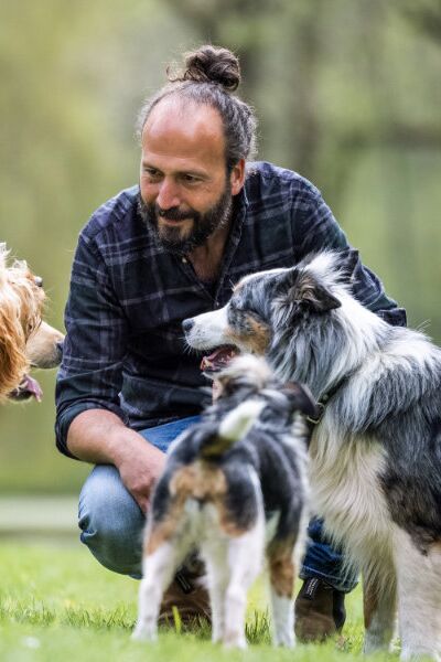 Jan Zander Sami El Ayachi kniend, von Hunden umgeben