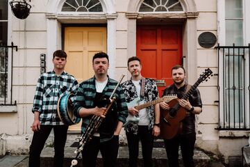 Connor Mallon Band vor Gebäude mit Instrumenten