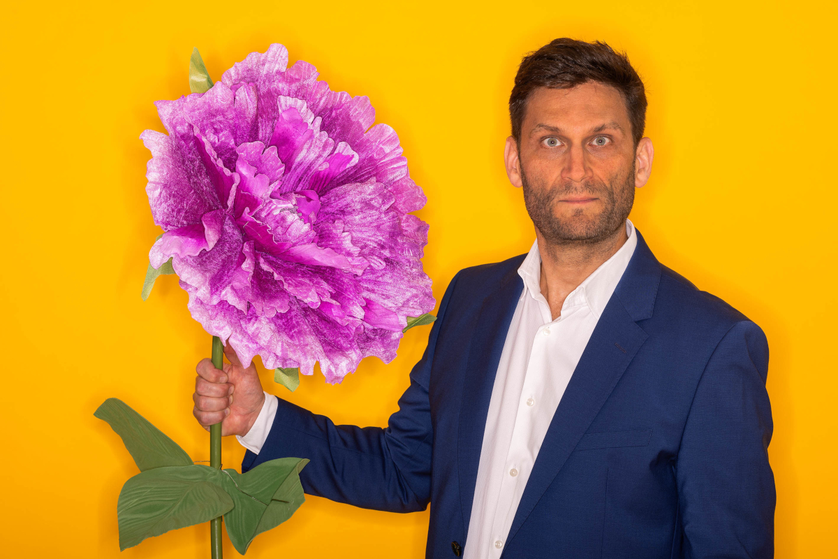 Christian Ehring mit Riesenblume in der Hand